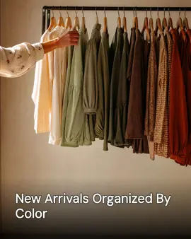 Generated post: a hand adjusting a hanger on a boutique clothing rack arranged in a colour gradient from cream through green to rust, headline about new arrivals organized by colour baked into the image